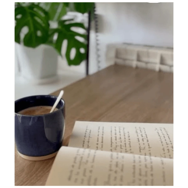 Proyecto de branding para Casa Raíces: fotografía de estilo de vida con café y libro en una mesa de madera